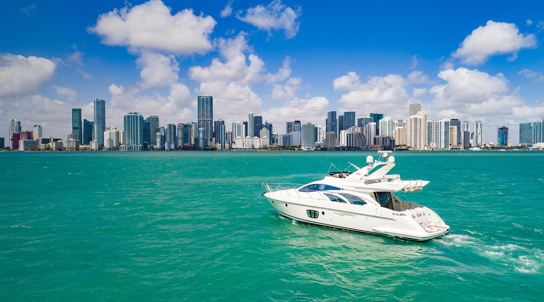 Yacht in the water in front of Miami skyline during bright sunny day